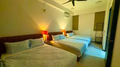 a hotel room with two beds and two lamps at Big screen cinema tv, 5 queen bed Luxury apt 2cp in Jelutong