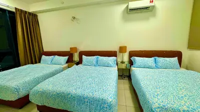 two beds in a hotel room with blue sheets at Big screen cinema tv, 5 queen bed Luxury apt 2cp in Jelutong