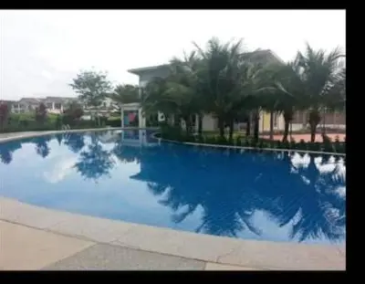 a large blue swimming pool with palm trees in the background at Mikayla Homestay in Ipoh