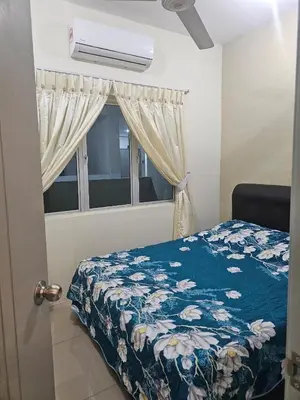 a bedroom with a bed with a blue floral bedspread and a window at Mikayla Homestay in Ipoh