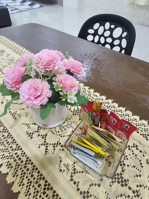 a vase filled with pink flowers on a table at Mikayla Homestay in Ipoh