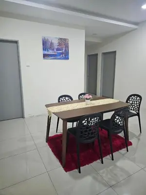 a dining room table with chairs and a painting on the wall at Mikayla Homestay in Ipoh