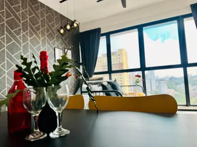 a dining room table with two wine glasses and flowers on it at CoZY FAMILY STAY GEORGETOWN 3BR -10PAX URBAN in Jelutong