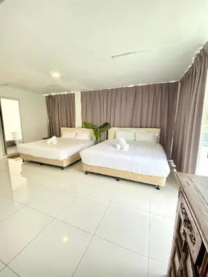 two beds in a room with white tile floors at Seahome Boutique Hotel in Tanjung Bungah
