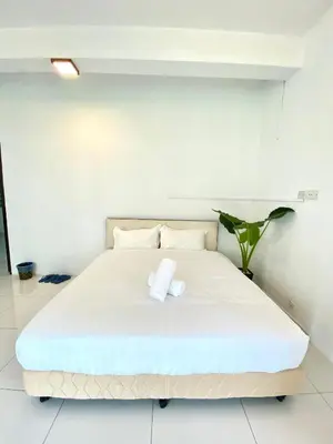 a white bed with two towels on top of it at Seahome Boutique Hotel in Tanjung Bungah