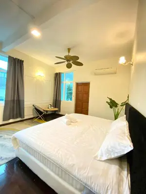 a bedroom with a white bed and a ceiling fan at Seahome Boutique Hotel in Tanjung Bungah