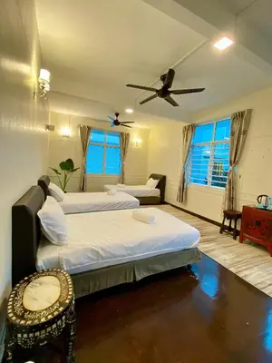 a bedroom with two beds and a ceiling fan at Seahome Boutique Hotel in Tanjung Bungah