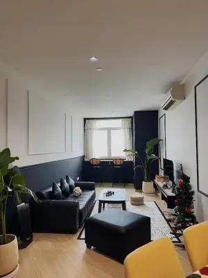 a living room with a black couch and yellow chairs at 118 Island Plaza by ZenZone88 in Tanjong Tokong