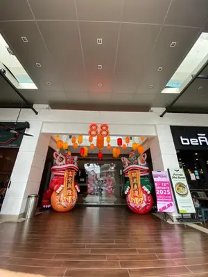 a shopping mall with a store with orange and red decorations at 118 Island Plaza by ZenZone88 in Tanjong Tokong