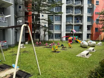 a playground in a park with a building in the background at Bright Apartment in Klebang in Ipoh