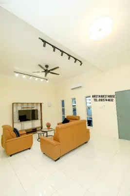 a living room with two couches and a flat screen tv at Arista Guest House in Pangkor