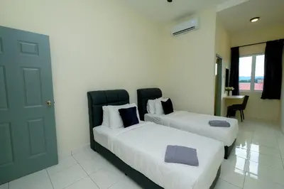 a bedroom with two beds and a door and a room at Arista Guest House in Pangkor