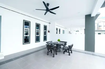 a dining room with a table and chairs and a ceiling fan at Arista Guest House in Pangkor