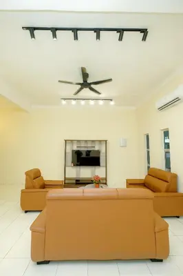 a living room with two couches and a ceiling fan at Arista Guest House in Pangkor