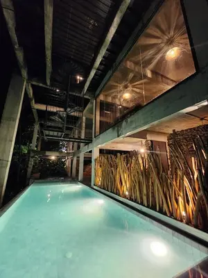 a swimming pool in a building with a wall of bamboo at The Wildwood Retreat KKB in Kuala Kubu Baharu