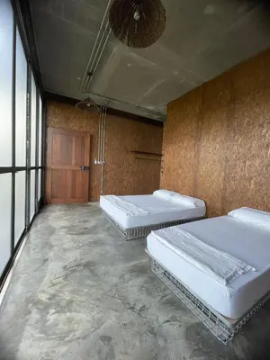 a room with three beds in it with a wall at The Wildwood Retreat KKB in Kuala Kubu Baharu