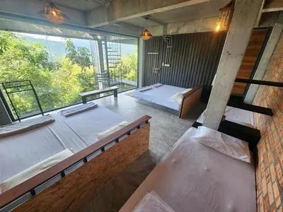 a room with two beds and a large window at The Wildwood Retreat KKB in Kuala Kubu Baharu