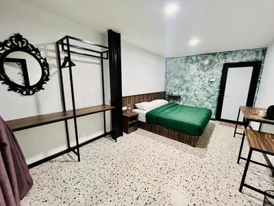 a bedroom with a green bed and a mirror at Big Dreams Hotel in Tanah Rata