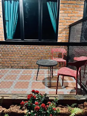 two chairs and a table in front of a building at Big Dreams Hotel in Tanah Rata