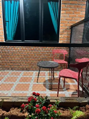 two chairs and a table in front of a building at Big Dreams Hotel in Tanah Rata