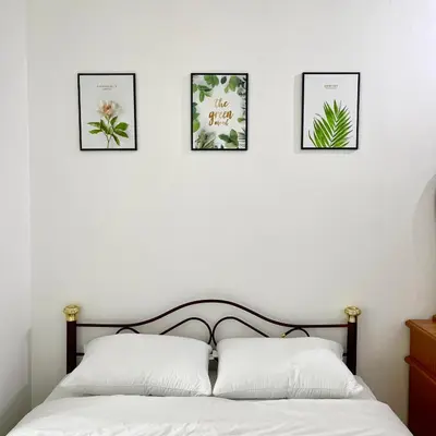 a bedroom with four pictures on the wall above a bed at Cozyhaus Ipoh in Ipoh