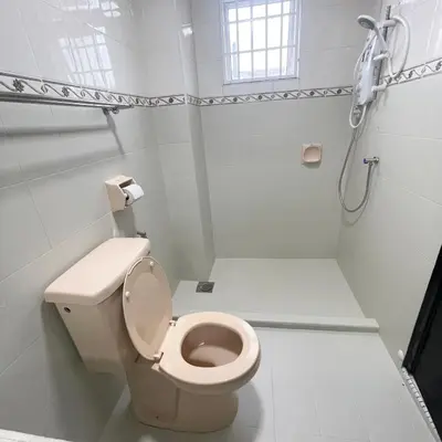 a white bathroom with a toilet and a shower at Cozyhaus Ipoh in Ipoh