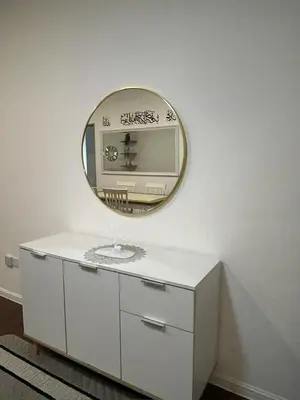 a mirror on a wall above a white dresser at Ella Residence Homestay in Brinchang