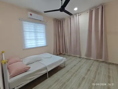 a bedroom with a bed with pink pillows and a window at Syakeel Homestay Bandar Bharu, Parit Buntar & Nibong Tebal in Bandar Baharu