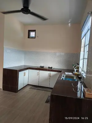 a kitchen with white cabinets and a ceiling fan at Syakeel Homestay Bandar Bharu, Parit Buntar & Nibong Tebal in Bandar Baharu
