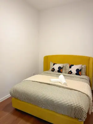 a bed with a yellow headboard and two pillows at 180View of Keafarm 7-9Pax CoolSummer at Palas Horizon in Tanah Rata