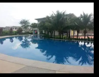 a large blue swimming pool with palm trees in the background at Mikayla homestay in Ipoh