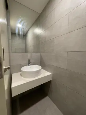 a bathroom with a white sink and a tile wall at Di Aran Residence Penang in Simpang Ampat