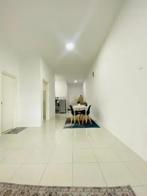 a white living room with a table and chairs at Aiqa homestay in Ipoh