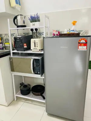 a kitchen with a refrigerator and a microwave at Aiqa homestay in Ipoh