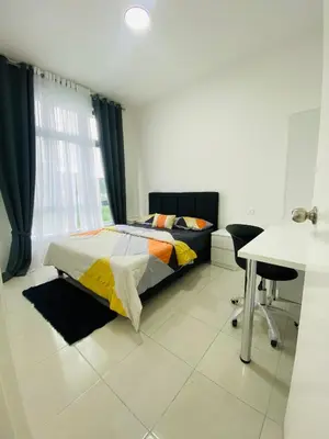 a bedroom with a bed and a desk and a table at Aiqa homestay in Ipoh