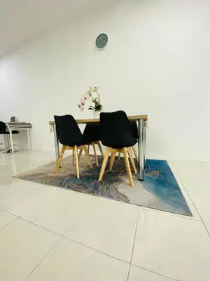a dining room table with two chairs on a rug at Aiqa homestay in Ipoh
