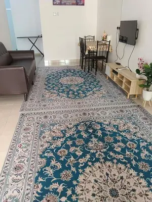 a living room with a table and a rug at Auni Homestay in Raub