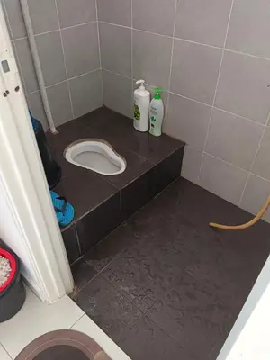 a bathroom with a toilet on a tiled floor at Auni Homestay in Raub