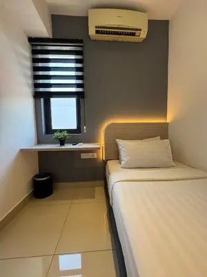 a small room with two beds and a window at Maca Hotel by Sky Hive in George Town