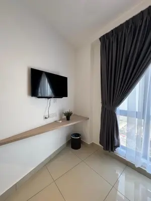 a living room with a tv and a window at Maca Hotel by Sky Hive in George Town
