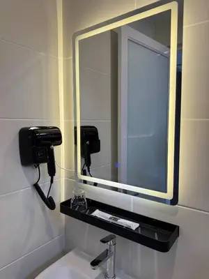 a mirror above a sink in a bathroom at Maca Hotel by Sky Hive in George Town