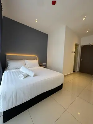 a bedroom with a large bed with white sheets at Maca Hotel by Sky Hive in George Town