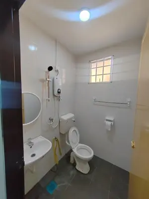 a white bathroom with a toilet and a sink at \u4f11\u95f2\u4f18\u6c11\u5bbf in Sitiawan