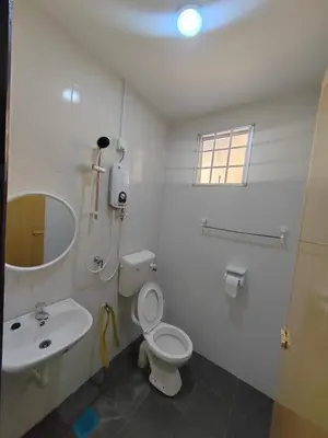 a white bathroom with a toilet and a sink at \u4f11\u95f2\u4f18\u6c11\u5bbf in Sitiawan