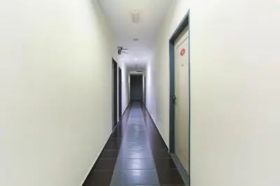 a hallway with white walls and a long corridor at De Hotel in Teluk Intan