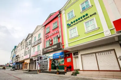 a row of colorful buildings on a city street at De Hotel in Teluk Intan