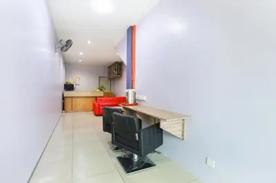 a kitchen with a table and chairs in a room at De Hotel in Teluk Intan