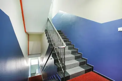 a staircase in a building with a blue wall at De Hotel in Teluk Intan