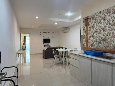 a kitchen and living room with a table and a couch at Marina Island Apartment, Lumut in Lumut