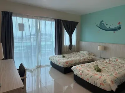 a hotel room with two beds and a window at Marina Island Apartment, Lumut in Lumut